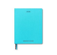 a blue notebook with the year 2020 on it and a black pen in front of it