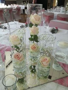 there are many vases with flowers in them on the table at this wedding reception