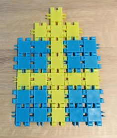 several blue and yellow pieces of plastic on a wooden surface with one piece missing from the top