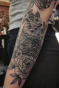 an owl and flowers tattoo on the arm