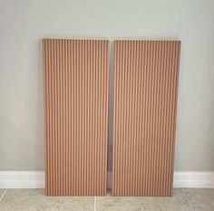 two wooden doors sitting next to each other in a room with tile flooring and white walls