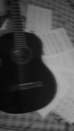 an acoustic guitar is sitting on top of sheet music