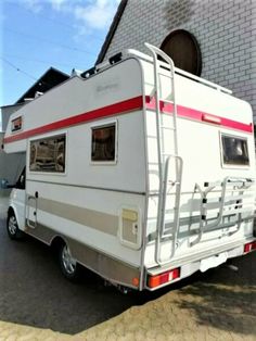 an rv parked in front of a brick building