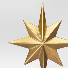 a gold metal star ornament on a white background