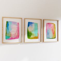 three framed art pieces hanging on the wall