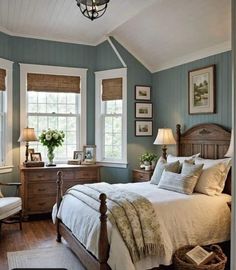 a bedroom with blue walls and white bedding, two windows in the ceiling and wooden furniture