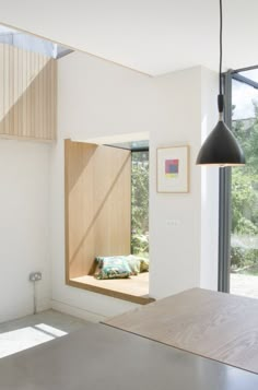 a room with a window and a bench in it next to a wall mounted light fixture