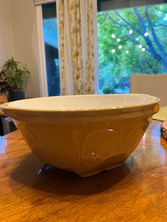 a yellow bowl sitting on top of a wooden table