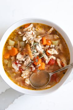 a white bowl filled with chicken and vegetable soup