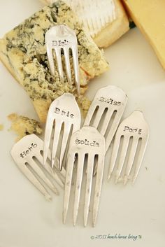 four forks with names on them sitting next to some food