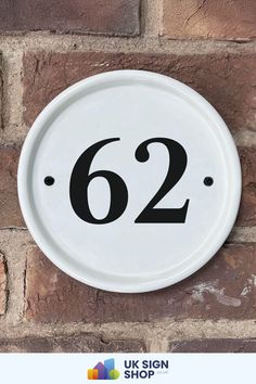 a white round sign on a brick wall with the number 662 in black lettering