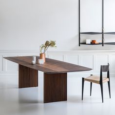 a wooden table and two chairs in a room with white paneling on the walls