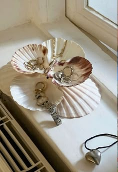 two seashells are sitting on a window sill with key chains attached to them