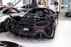 two black sports cars parked in a showroom