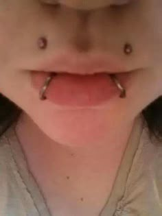 a woman with two piercings on her tongue