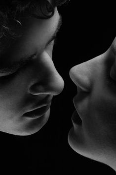 black and white photograph of two people facing each other with their noses close to one another