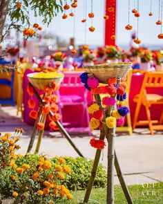 an outdoor event decorated with colorful flowers and hanging decorations for the centerpieces in the ceremony