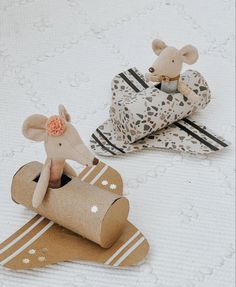 two small wooden mice sitting on top of toilet paper roll rolls in the shape of mouses