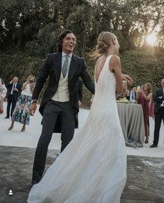 a bride and groom are dancing at their wedding reception in front of an outdoor crowd