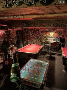 a group of people playing foo - pong in a room with graffiti on the walls