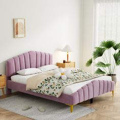 a bed room with a neatly made bed and a potted plant