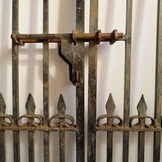 an old metal gate with rusted iron bars on it's top and bottom