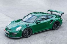 a green porsche sports car parked in a parking lot