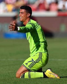 a soccer player sitting on the ground with his hands out