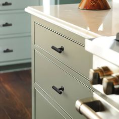 a white dresser with drawers and knobs on it