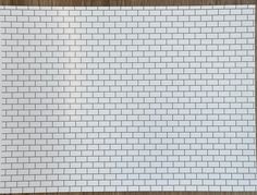 a piece of white paper that is on top of a wooden table with a black and white brick pattern