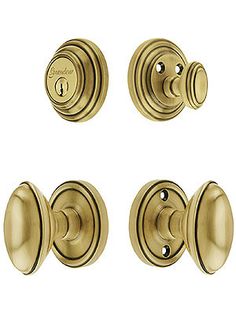 four brass door knobs and handles on a white background