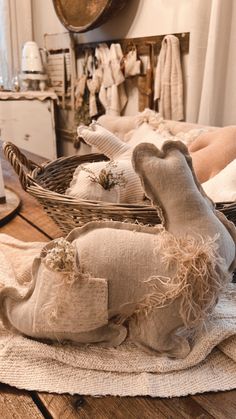 a basket filled with stuffed animals sitting on top of a wooden table next to pillows