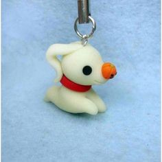 a keychain shaped like a dog with a carrot in it's mouth