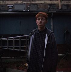 a young man standing in front of a building