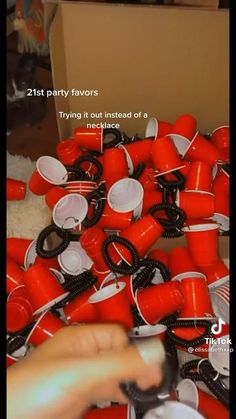 a bunch of red cups sitting on top of a table next to a cardboard box