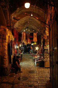 an alley way with people shopping at night