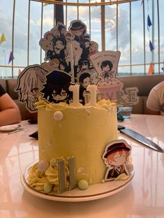 a yellow cake sitting on top of a white table next to a metal rack filled with magnets