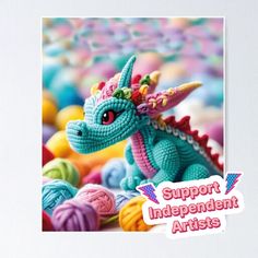 an image of a toy dragon surrounded by balls of yarn