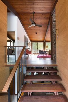 the inside of a house with wood floors and stairs leading up to an open floor plan