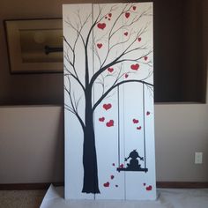 a painting of a tree with hearts hanging from it's branches and a man sitting on a swing