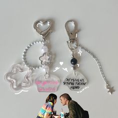 two key chains attached to each other on a white surface with an image of a man and woman