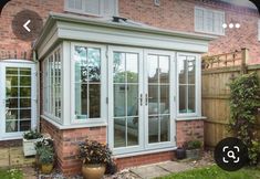 an orange brick house with glass doors and windows