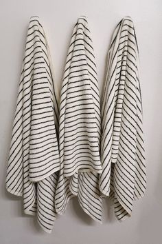 three black and white striped towels hanging on a wall