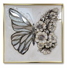 a white and gold butterfly with flowers on it's wings is shown in a golden frame