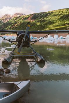 an airplane sitting in the water with icebergs behind it