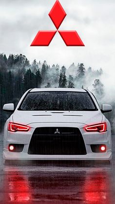 the front end of a white car driving on a wet road with trees in the background