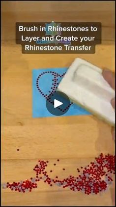 a person is cutting up red beads on a wooden surface with a video screen showing how to use them