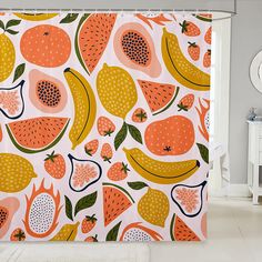 an orange and yellow shower curtain with fruit on it in a bathroom area next to a toilet