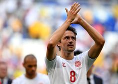 a soccer player holding his hands up in the air