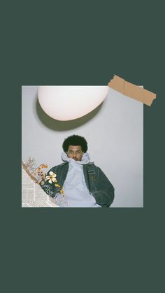 a young man sitting in front of a lamp